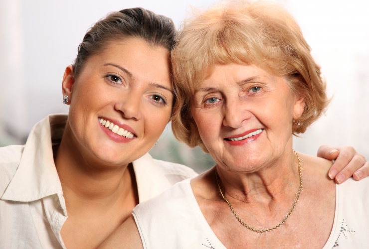 A beautiful portrait of grandma and grandaughter smiling over white background
