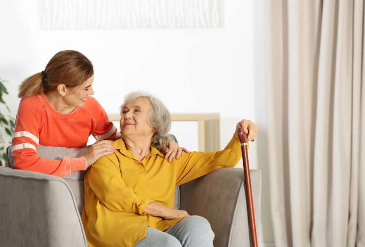 Elderly woman with female caregiver in living room